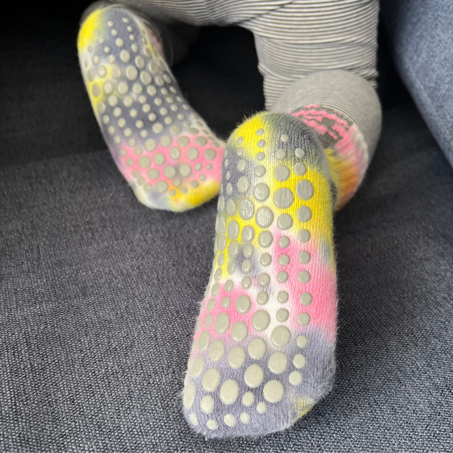 A toddler crawling and showing feet soles covered in grip socks.