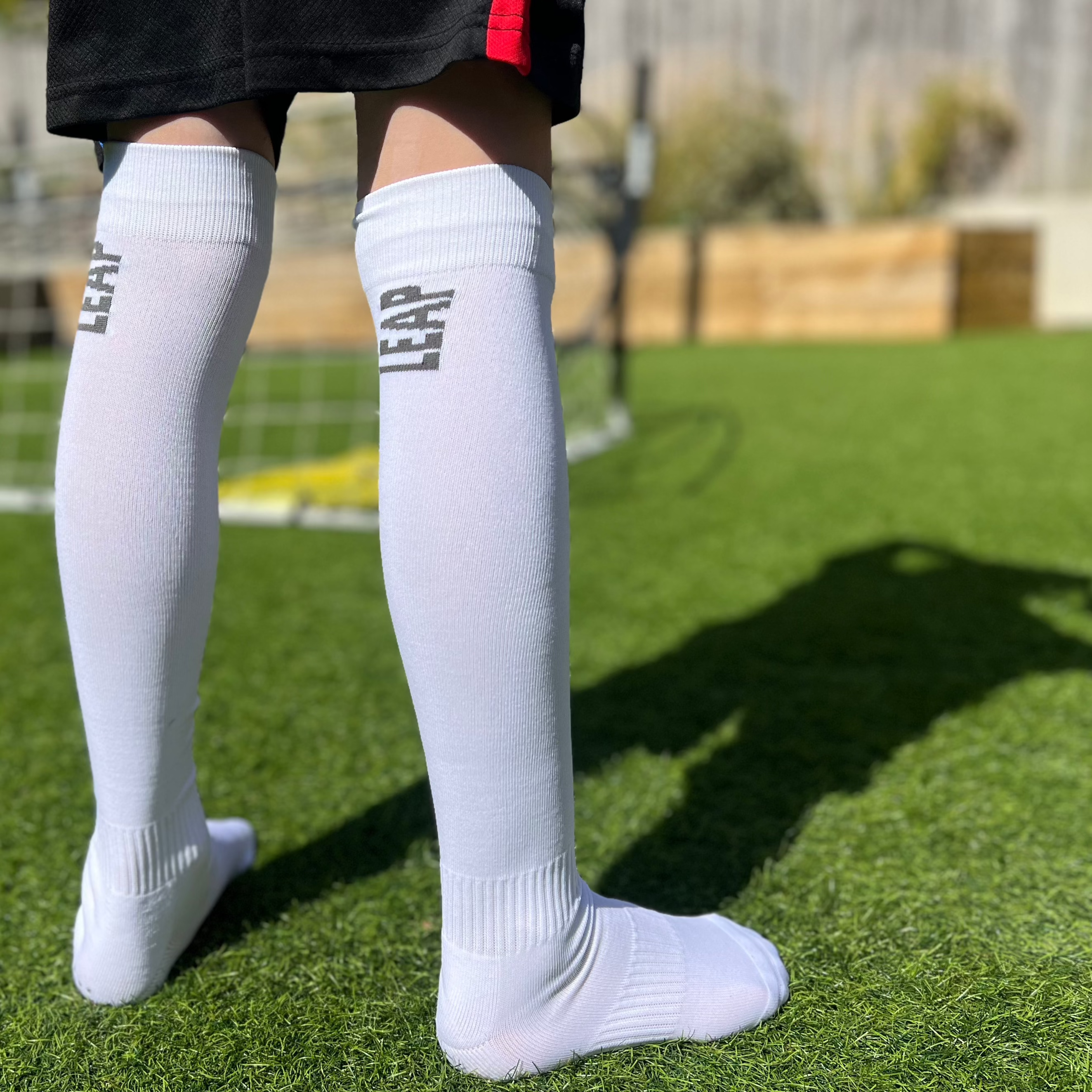 A child wearing white knee high LEAP football socks.