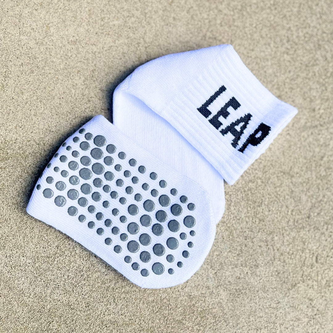 A folded top and bottom view of Leap ankle football grip socks.